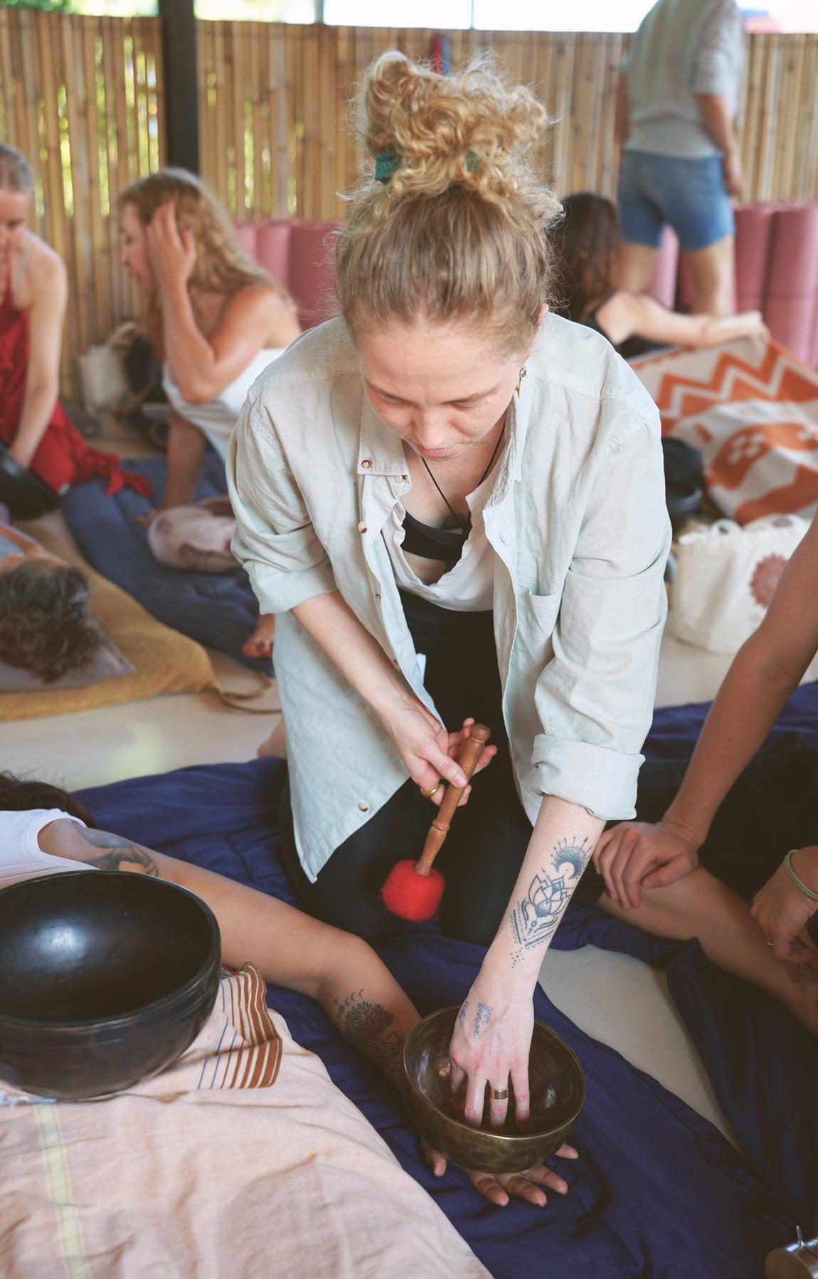 Anna placing singing bowls on the body during a session
